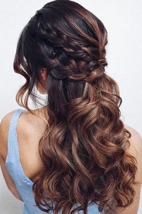 a beautiful boho half updo with a double braided halo and waves down, waves framing the face and caramel balayage that makes it cooler