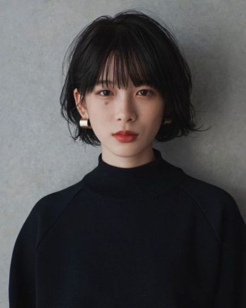 a black jaw-length bob with wispy bangs and messy waves is a stylish and very up-to-date idea