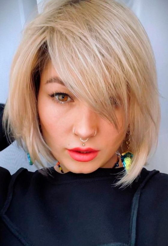 a chin-length creamy blonde bob with side bangs and plenty of movement and texture