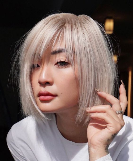 a chin-length platinum blonde bob with wispy bangs and side parting is a classyc and very airy-looking solution