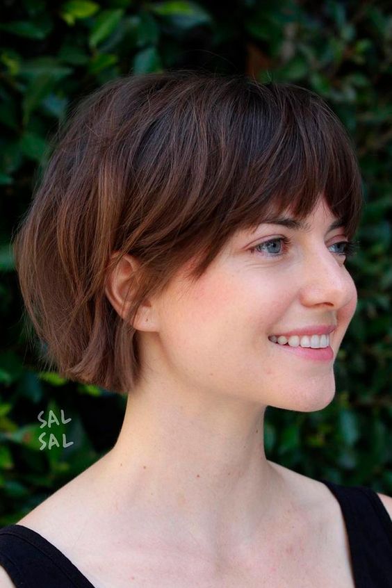 a dark brunette jaw-length bob with caramel balayage and layered bangs is a catchy idea to rock right now