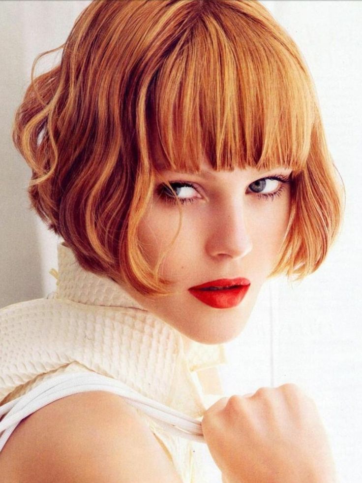 a ginger ear-length bob with a thick classic fringe and waves is a super bold and eye-catching idea that wows