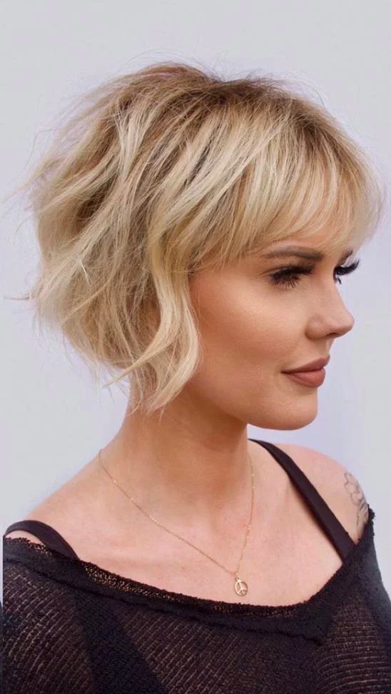 a lovely ear-length blonde bob with a classic fringe and messy waves plus a lot of volume is very chic