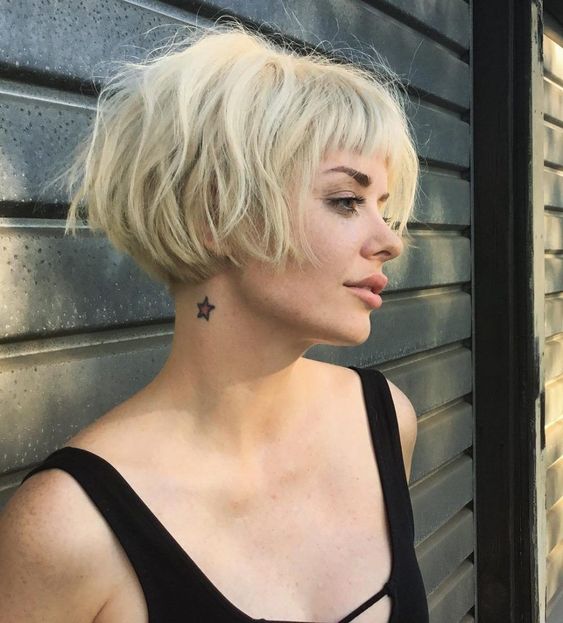 a lovely short blonde messy ear-length bob with a classic fringe and dimension looks very grunge-like