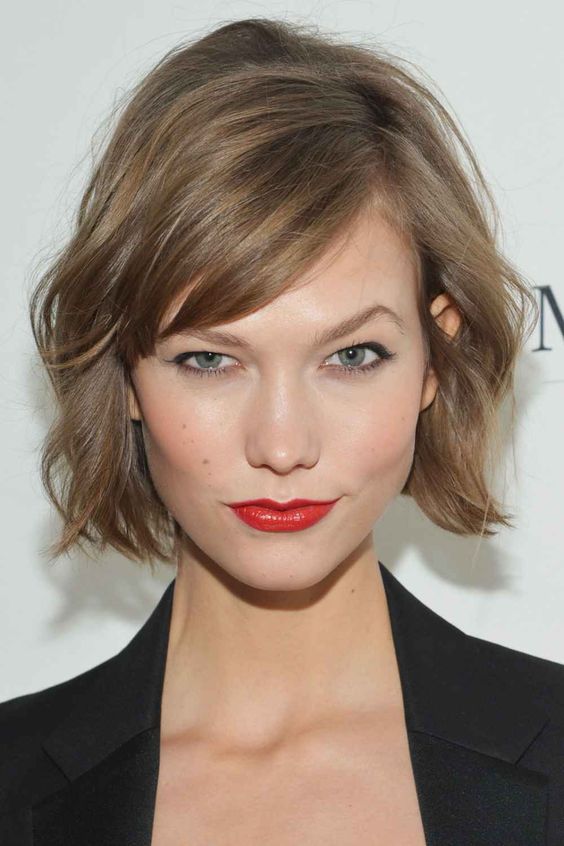 a mousy brown jaw-length bob with side bangs and messy waves is a lovely solution with effortless chic