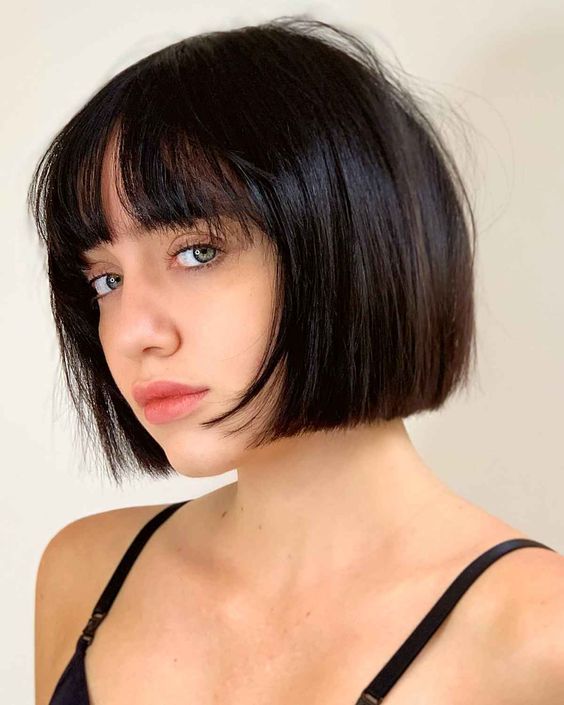 an elegant black chin-length bob with wispy bangs is a classy idea, this length matches many face shapes, and bangs are airy