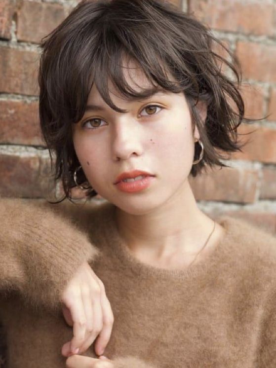 a brown messy and layered boy bob with bangs is a chic and relaxed idea to pull off