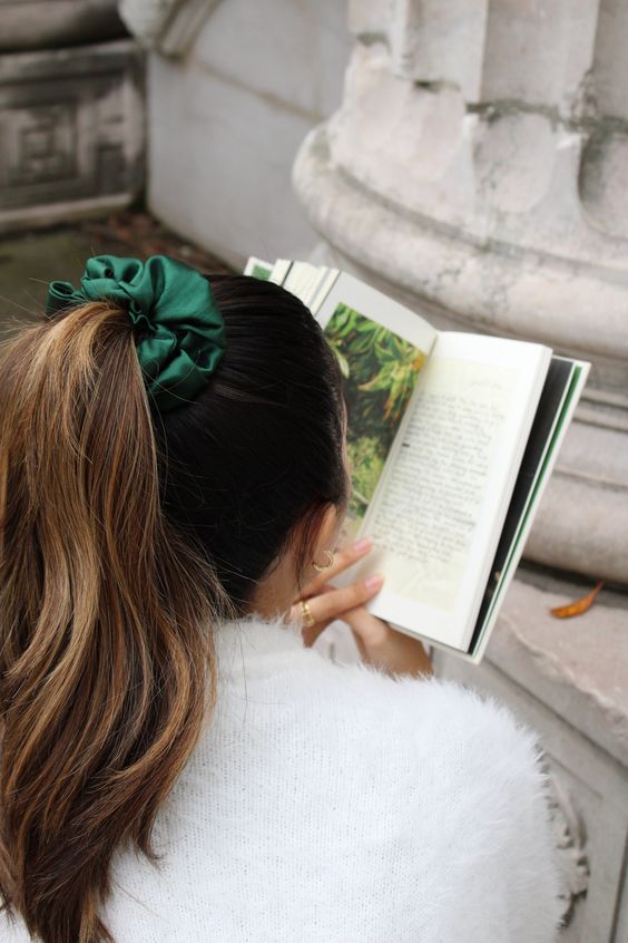 a classic high ponytail with a sleek top and wavy hair down plus an emerald silk scrunchie for a colorful accent