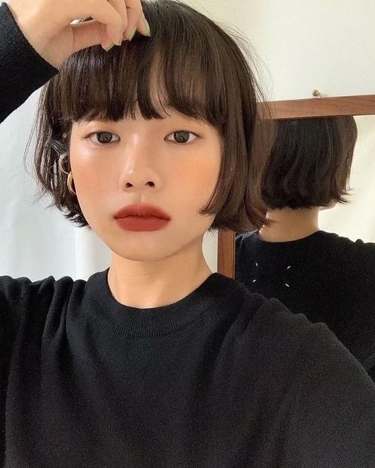 a brunette ear-length bob with outgrown bangs and messy texture is a lovely idea