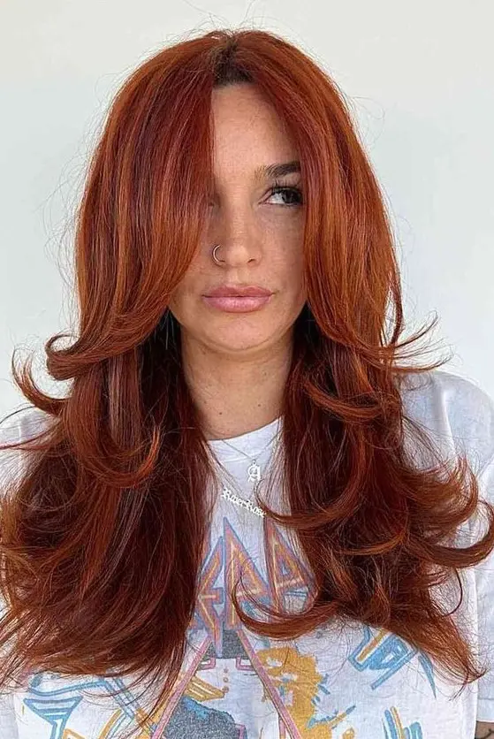 a fab red butterfly haircut on long hair, with a lot of volume, face-framing layers and curled ends is jaw-dropping