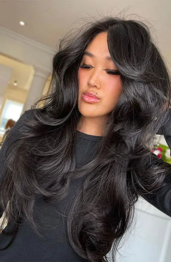 a gorgeous black butterfly haircut with curled ends, a lot of volume and curtain bangs is amazing