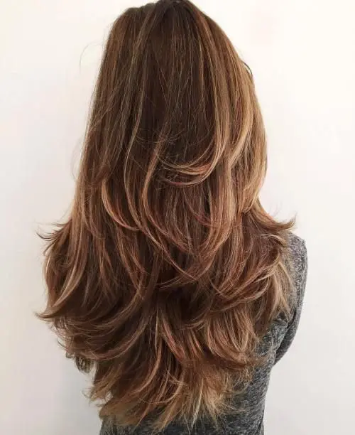 beautiful brown long hair with caramel balayage and a butterfly haircut to give it volume and interest