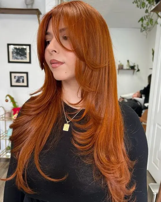 a stunning bright copper long butterfly haircut with face-framing layers and curled ends is amazing