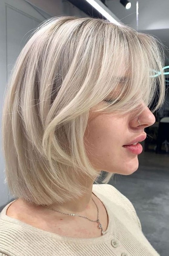 a chic icy blonde long bob with curtain bangs is a very cool idea that feels modern and edgy