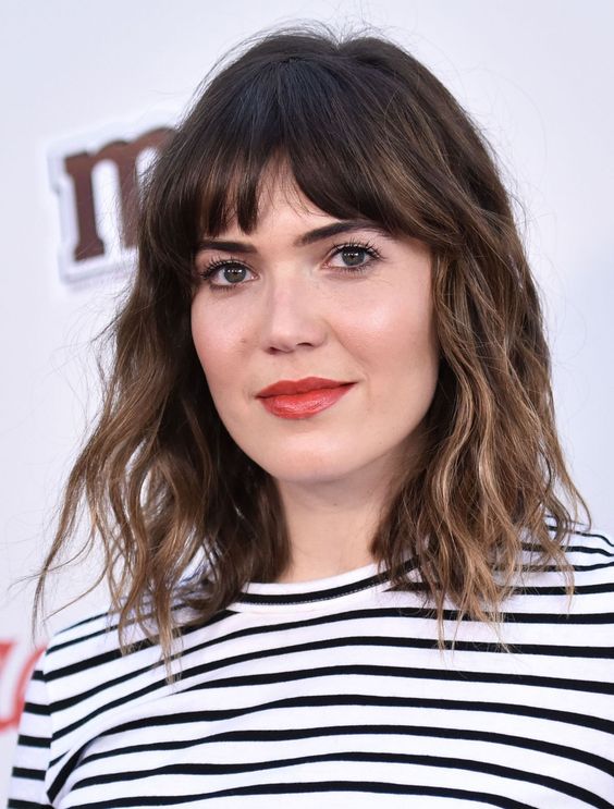 a long dark brunette bob with bronde balayage, bottleneck bangs and waves is a chic and French-inspired idea