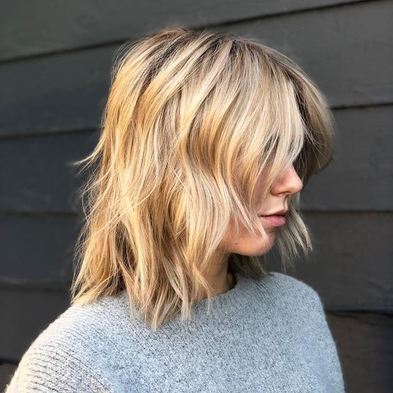 a messy blonde wavy long bob with curtain bangs is a chic and relaxed idea to rock any time