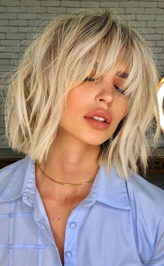 a pretty and trendy long bob haircut of cool vanilla tone and with bangs and messy waves is amazing for summer