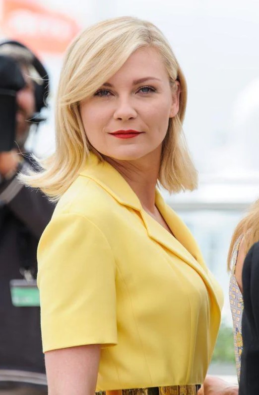 Kirsten Dunst's highlighted hair had been styled into a deep side parting and beautiful curtain bangs looks gorgeous