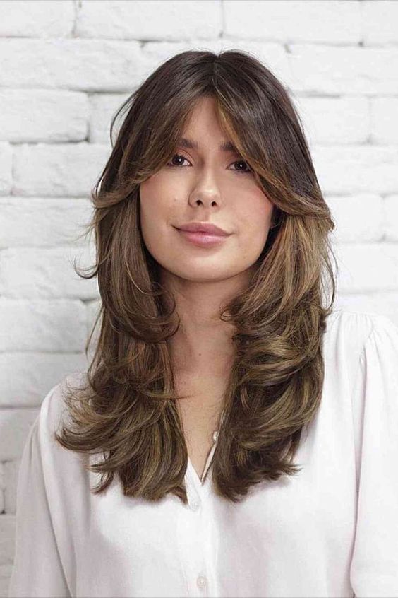 a splendid butterfly haircut in brown, with caramel balayage and curtain bangs is a gorgeous idea