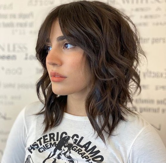 a cool brown medium wolf cut with waves that make it softer and bottleneck bangs is a lovely idea