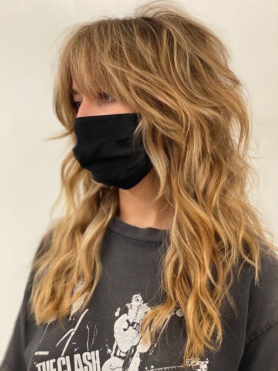 a honey blonde wolf cut with bottleneck bangs and waves down plus messy texture is a very chic idea