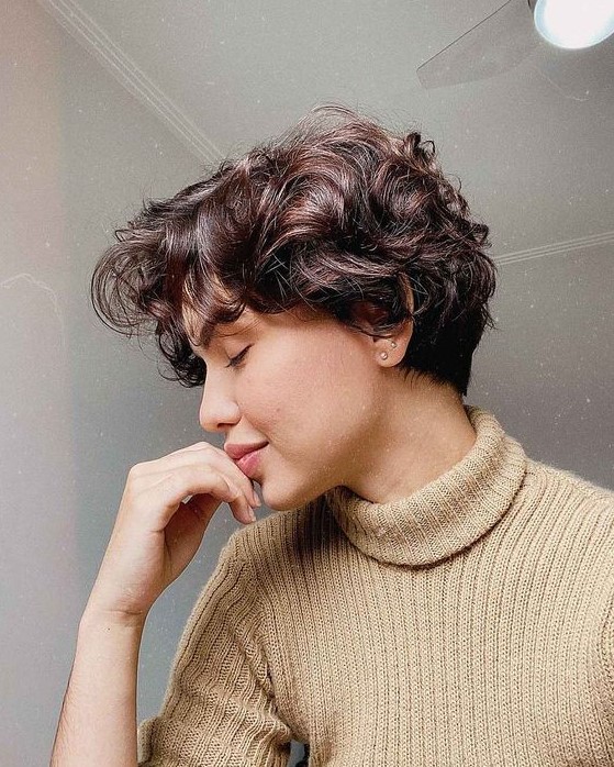 a dark brown wavy and curly pixie with a bit of short bangs is a lovely and cute idea to rock