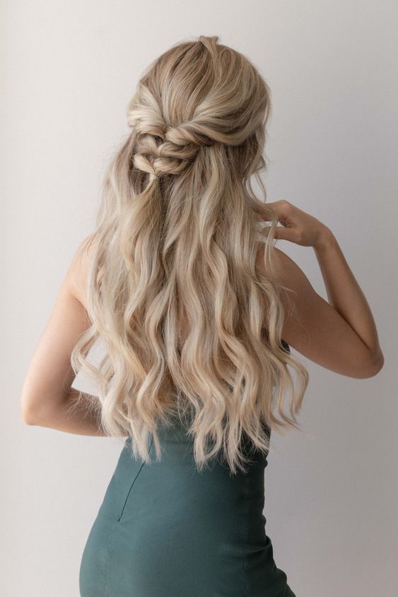 a classy half updo with a volume on top, waves and a loose braid is a beautiful idea for both long and medium hair