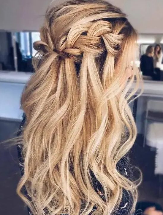 a long wavy half updo hairstyle with a braided halo and locks down for a boho feel