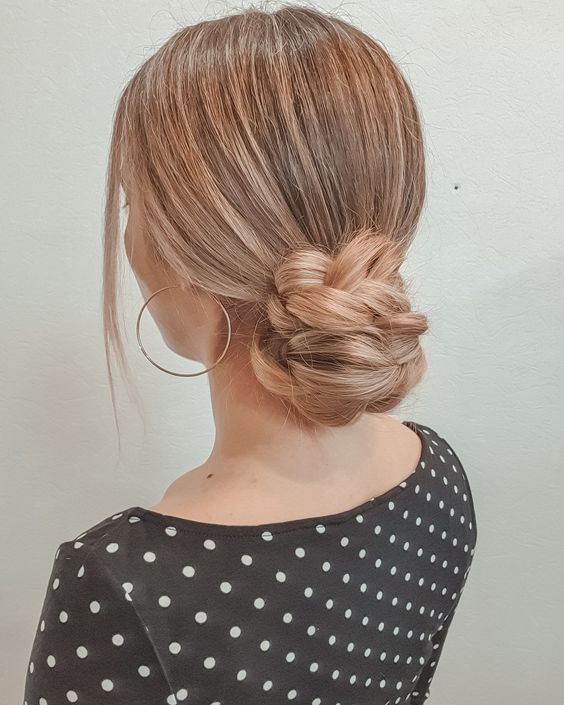 a braided low bun with a sleek top and face-framing hair is a catchy and cool solution for a Christmas party