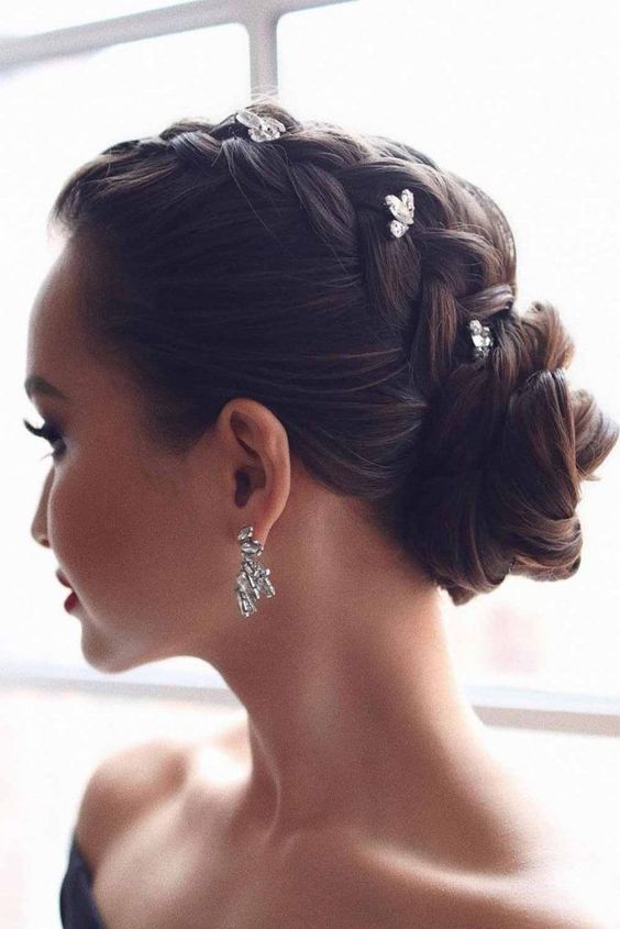 a glam updo with a braid on top and a low bun accented with rhinestone hairpins is a cool and catchy idea for holidays