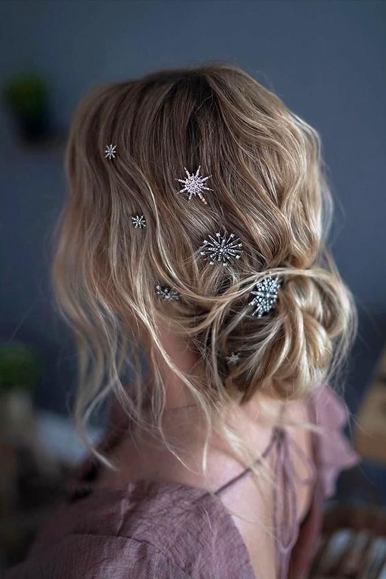 a lovely low bun with a messy wavy top, some locks down and beautiful celestial hair pins