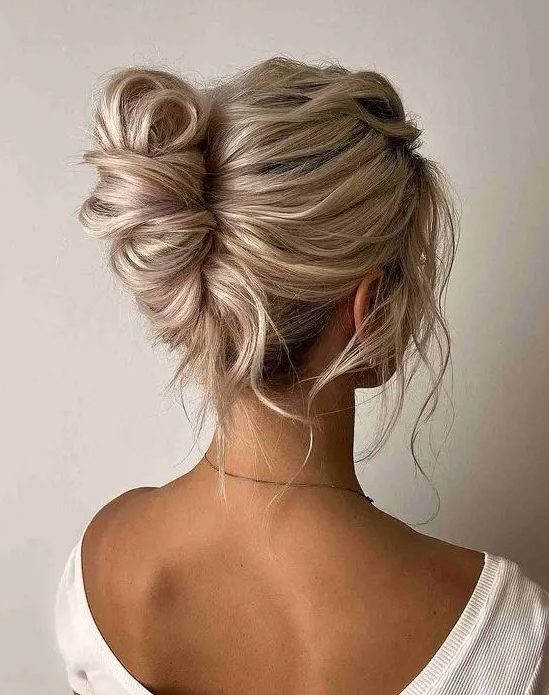 a lovely messy and twisted chignon hairstyle with a messy wavy top and some locks down is a lovely idea