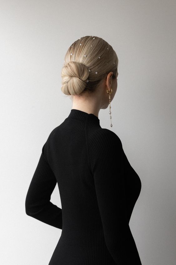 a stylish tight woven low bun with pearl hair pins will be a refined and chic party hairstyle to rock