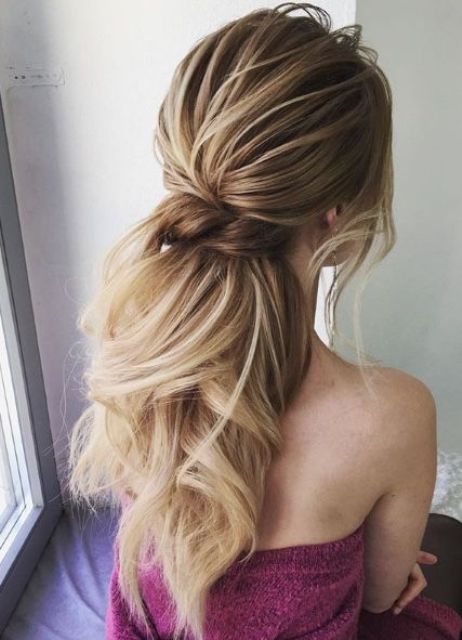 a low twisted ponytail with waves, a bump and bangs is a gorgeous idea to show off your hair