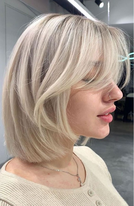 a chic icy blonde long bob with curtain bangs is a very cool idea that feels modern and edgy