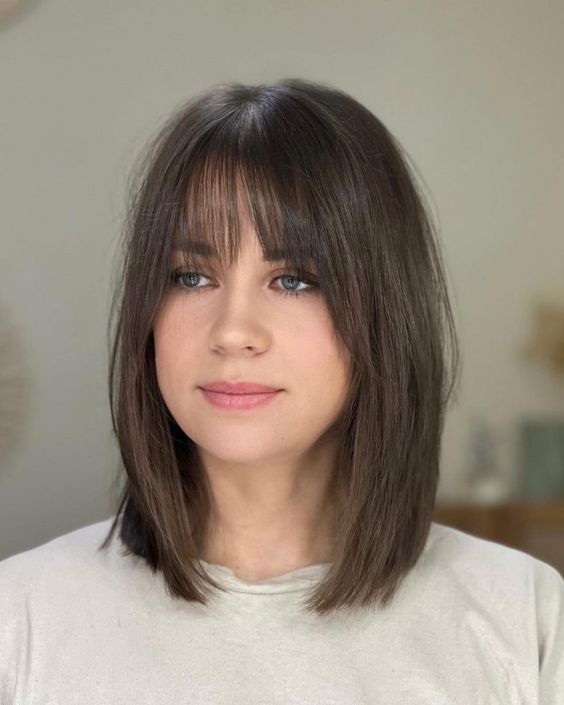 a brunette long bob with wispy bangs is a cool idea, and such bangs will accent the eyes