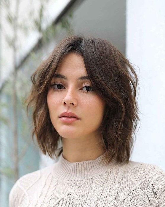 a shaggy and layered brown long bob with curtain bangs and central parting is a cool and very up-to-date idea to try right now