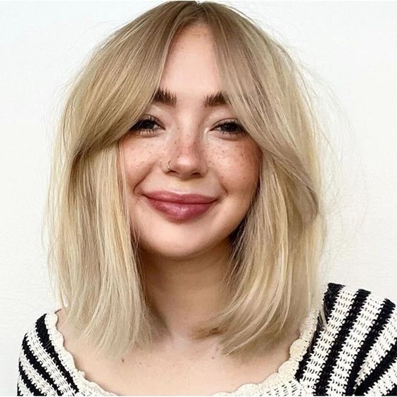 a pretty long blonde bob with curtain bangs and a lot of volume is a stylish and chic idea to rock