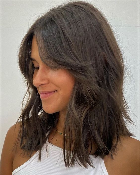 messy and shaggy dark brunette medium-length hair with short curtain bangs