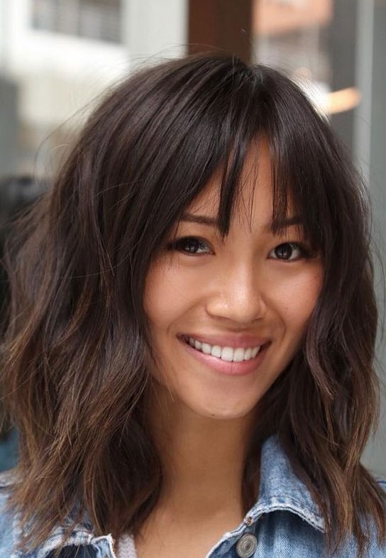 a cute layered lob with bottleneck bangs and a rich brown tone is a very chic and cool idea for a wearing now